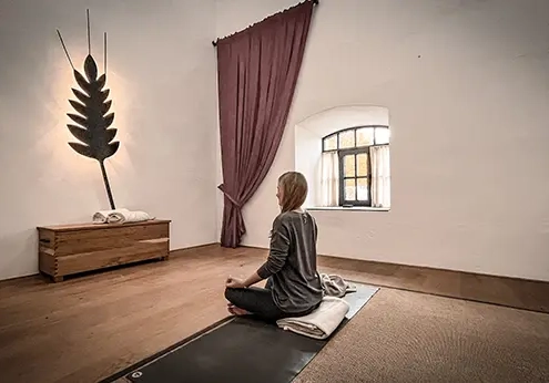 Bei vollkommener Stille, meditiert Marion Sommer in der ehemaligen Getreidedarre dem „Raum der Stille“.